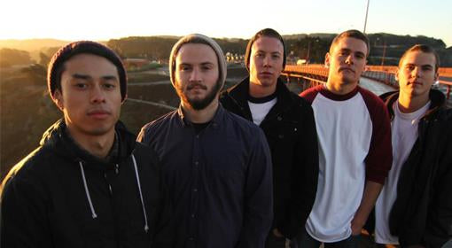 Five young men stand outdoors on a bridge at sunset, wearing casual jackets and t-shirts, looking directly at the camera with serious expressions.