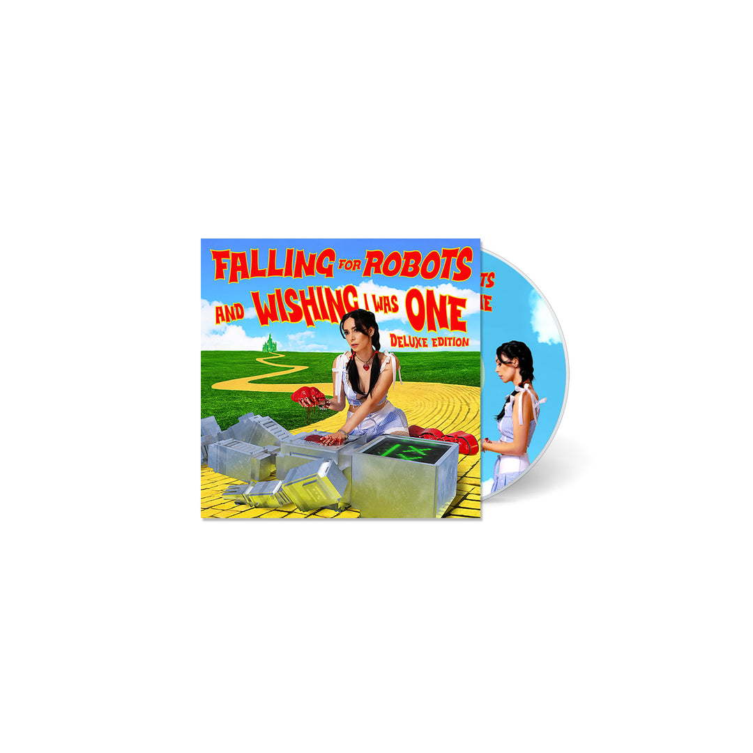 A CD case and disc from L0L0 feature a cartoon girl on a yellow brick path with robots in green fields. The title reads Falling for Robots and Wishing I Was One Deluxe Edition, inspired by u & the tin man.