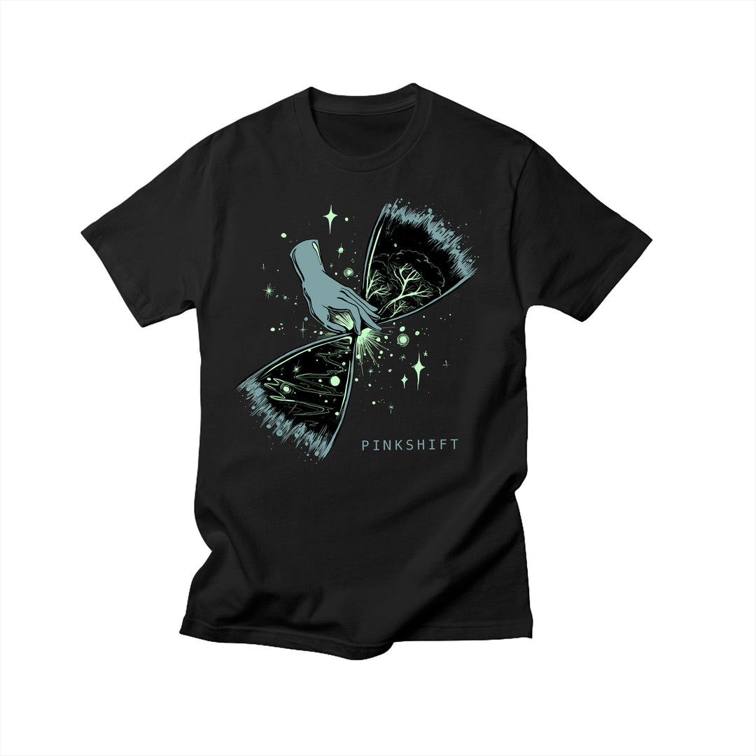 Exclusive Pinkshift design on a black Comfort Colors T-shirt shows an illustrated hand tearing open a starry sky to reveal branches and leaves. PINKSHIFT is printed beneath the artwork.