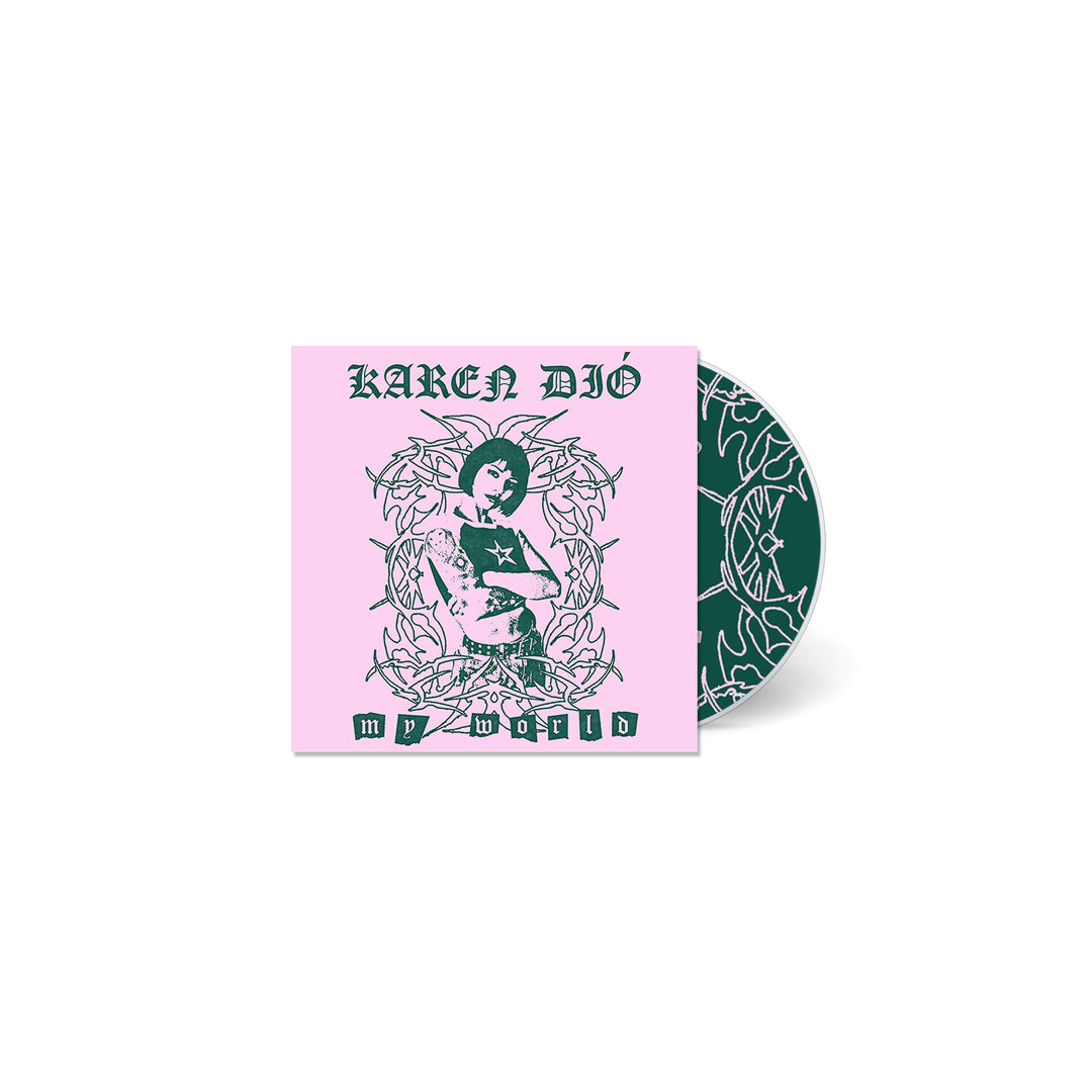 A CD case from Karen Dió with a pink cover showing an illustrated person among ornate designs. The cover says KAREN DIÓ and MY WORLD. The partially visible CD has a matching dark green pattern—funny, unique, and stylish.