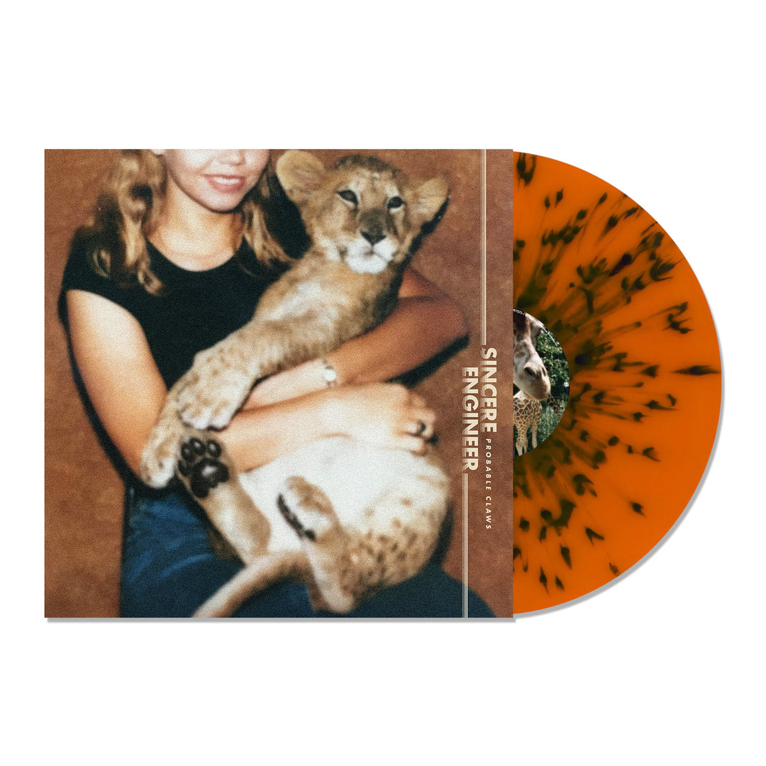 A limited edition orange and black splatter vinyl is partially slid out of an album cover showing a person holding a lion cub, with the brand name Sincere Engineer displayed.