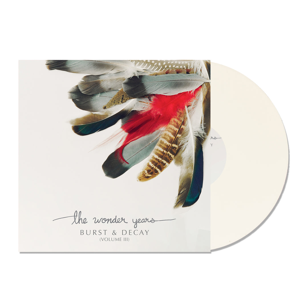 A white vinyl record partially slides from an album cover with multicolored feathers. In handwritten style, the text reads The Wonder Years BURST & DECAY (VOLUME III). Volume III contrasts boldly with the vibrant artwork.