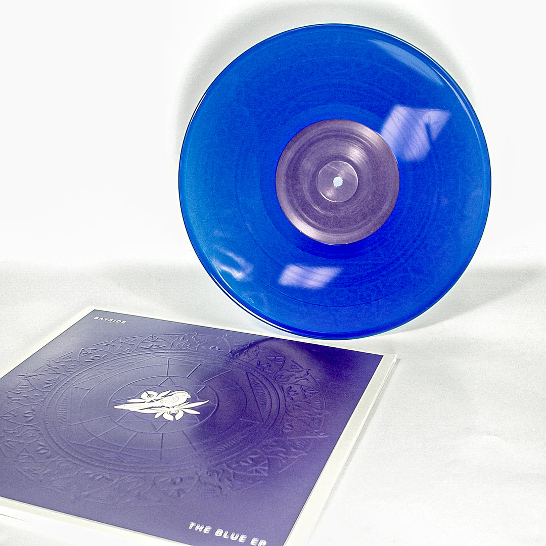 Vinyl album cover for Bayside "The Blue EP" on a white background. Cover is Blue with a Mandala. White bird on a flower centered. White Text in the corners "Bayside" &amp; "The Blue EP". Vinyl is Transparent Blue.