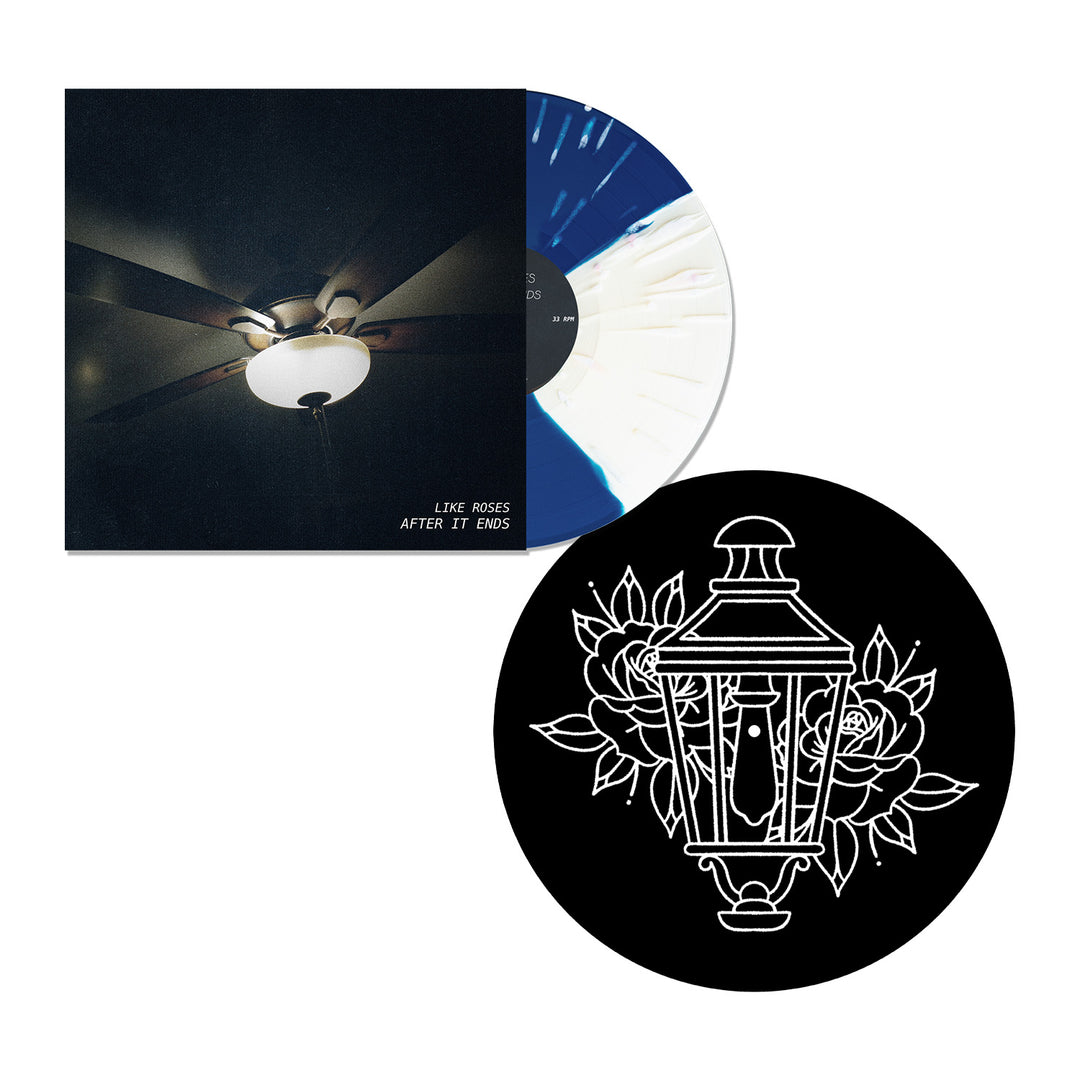 A limited edition vinyl record with a blue and white swirl, an album cover featuring a ceiling fan, and a black circular item with a white lantern and floral design are displayed on a white background.