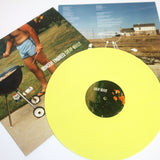 A yellow LP labeled Cheap Grills rests atop two album covers—one with a shorts-clad barbecuer, the other with a grill and suburban house—perfectly capturing the Sincere Engineer brand’s vibe.