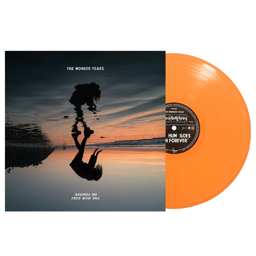 An orange vinyl record by The Wonder Years partially slides from an album cover featuring a sunset, a silhouette with their reflection on water, and the text "The Wonder Years – The Hum Goes On Forever." Ideal for orange vinyl collectors.