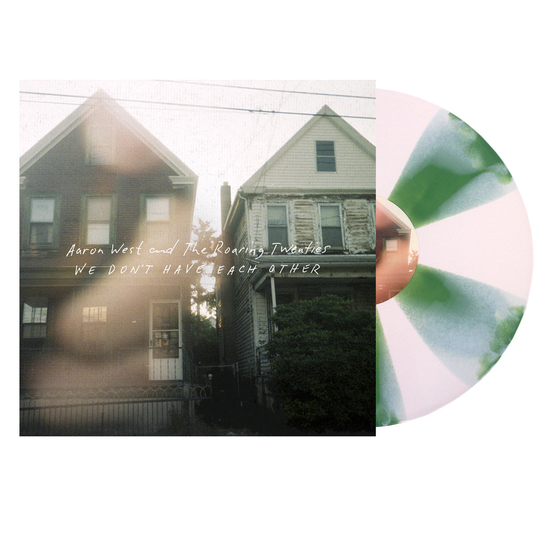 A green and white splatter vinyl record by Aaron West and the Roaring Twenties peeks from its cover, which shows two houses and reads WE DON’T HAVE EACH OTHER—plus a possible bonus track.