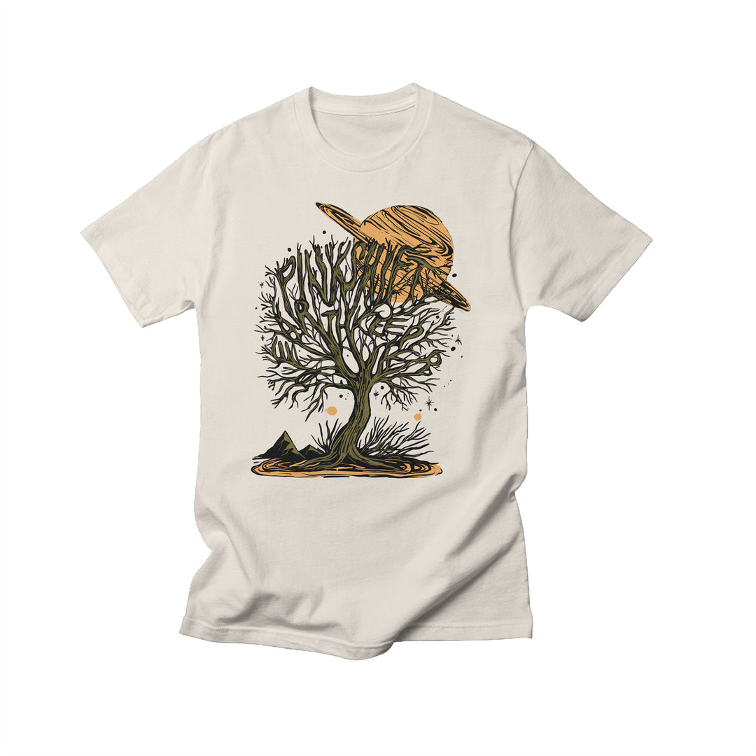 Pinkshift off-white Comfort Colors t-shirt with an exclusive print: a leafless tree with surreal black branches, set against a large orange ringed planet for a cosmic, mystical vibe.
