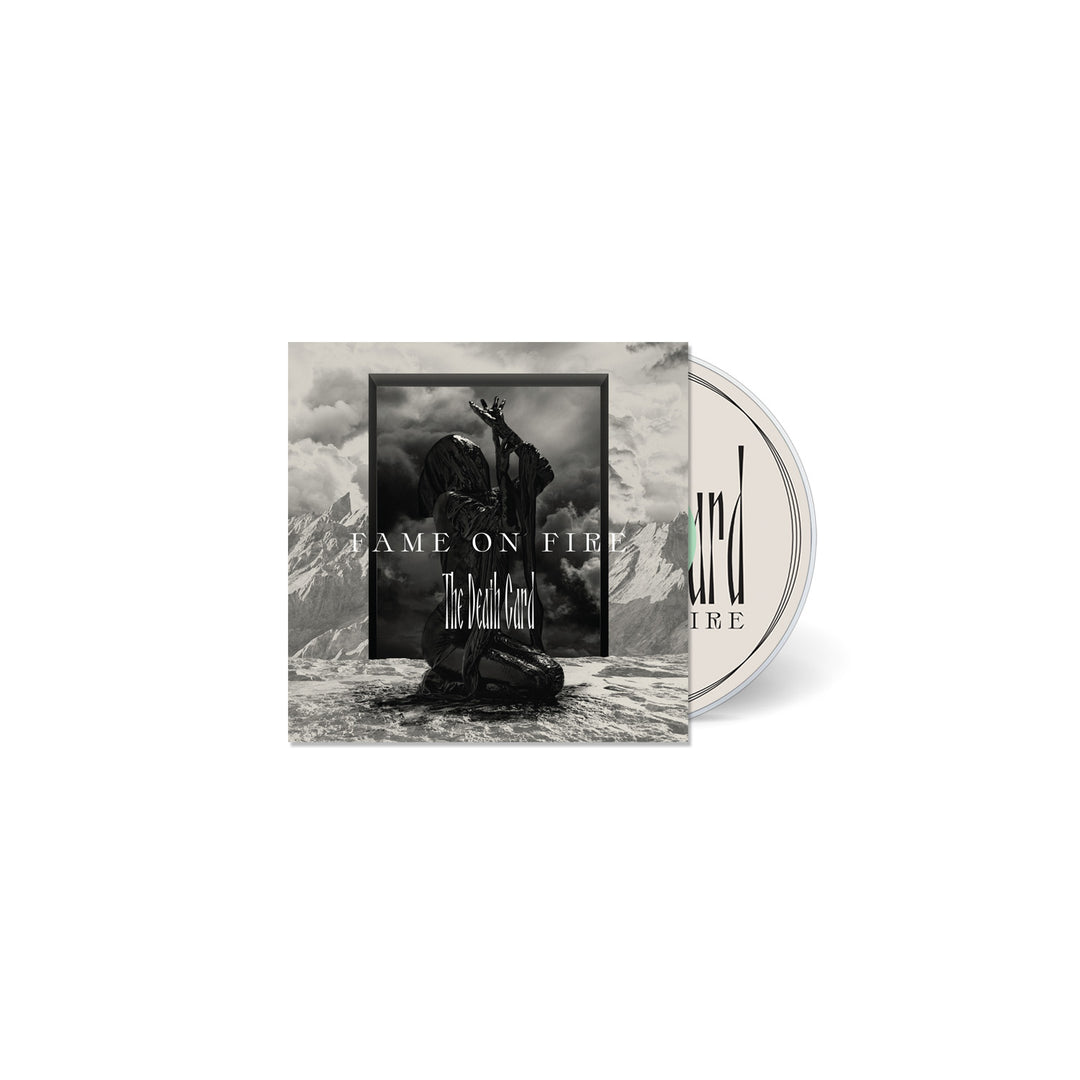 CD cover featuring a black and white image of a statue-like figure kneeling on rocky ground with mountains behind. Text reads FAME ON FIRE and The Death Card, evoking a sense of nightmare. The partially visible CD is included.
