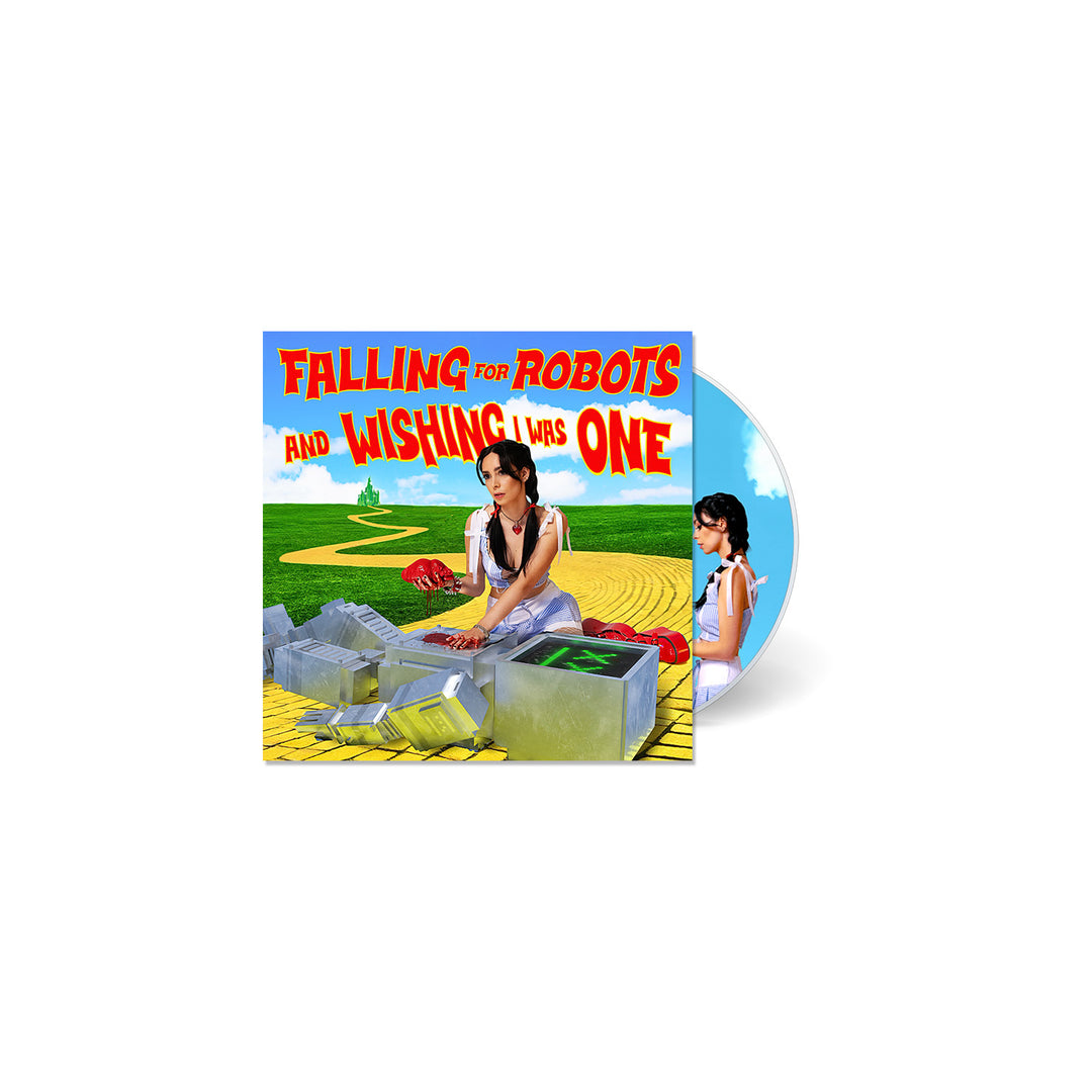 A CD cover from L0L0 shows a woman dressed as Dorothy from The Wizard of Oz beside robot parts on a yellow brick road, with the title Falling for Robots and Wishing I Was One in bold red and yellow text.