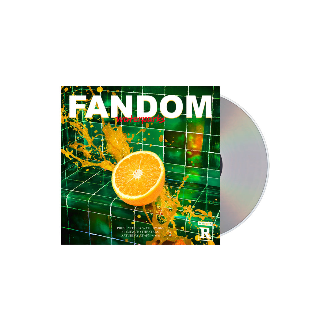Waterparks FANDOM CD cover features a sliced orange splashing juice on green tiles, bold white title, and a partially revealed disc—highlighting tracks like Dream Boy and Easy To Hate.