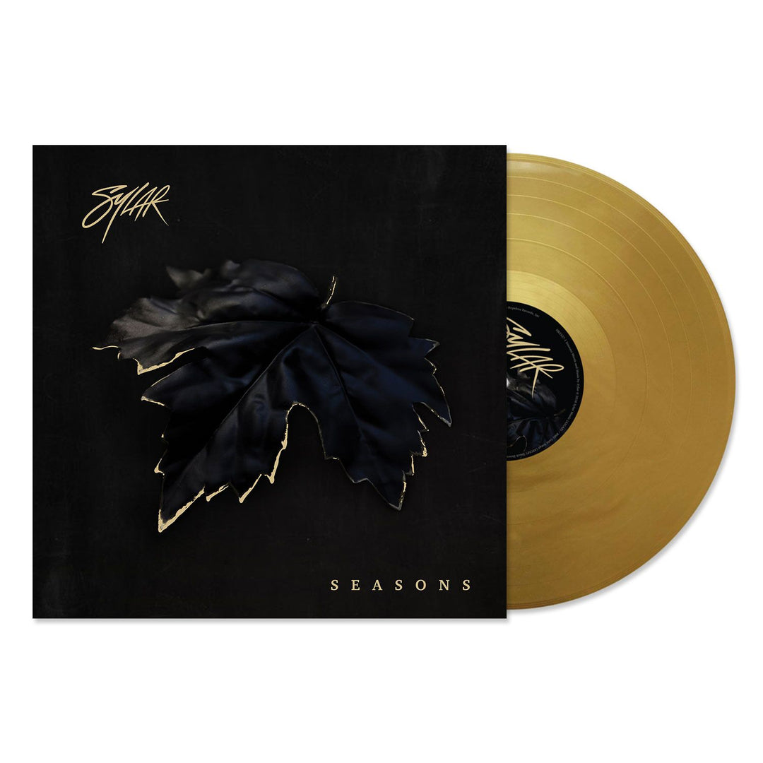 A gold vinyl record slides from a black cover featuring a dark leaf with gold edges, evoking winter. The cover shows the brand name “Sylar” and the title “SEASONS” in white lettering.