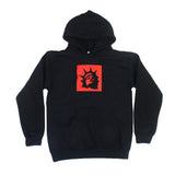 Trophy Eyes black hoodie with a front pocket, featuring a red square on the chest with a black Statue of Liberty head graphic—an iconic piece from the Liberty Square Black collection.