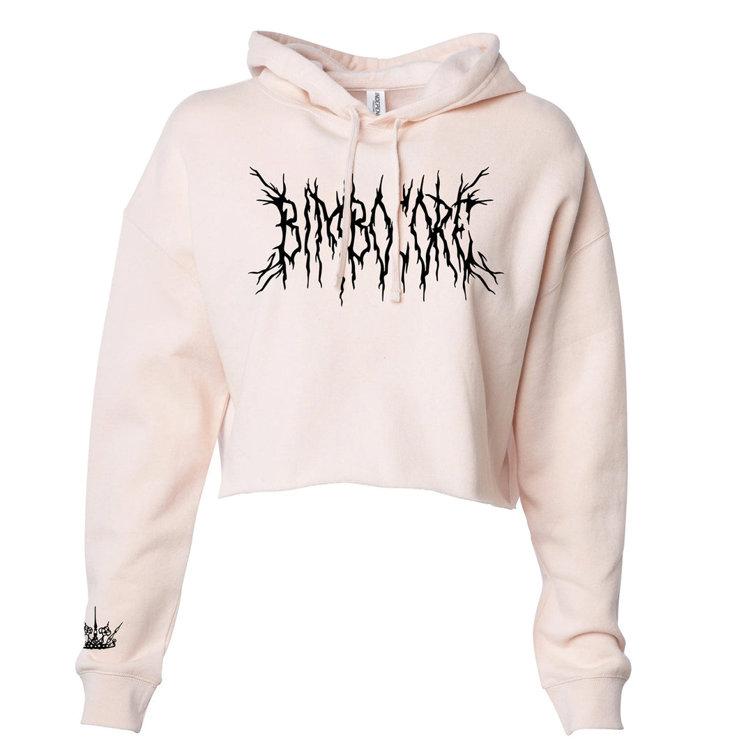 Bone cropped pullover on a white background. Metal Text in red "Bimbocore". Right sleeve has a crown in black around the wrist. 