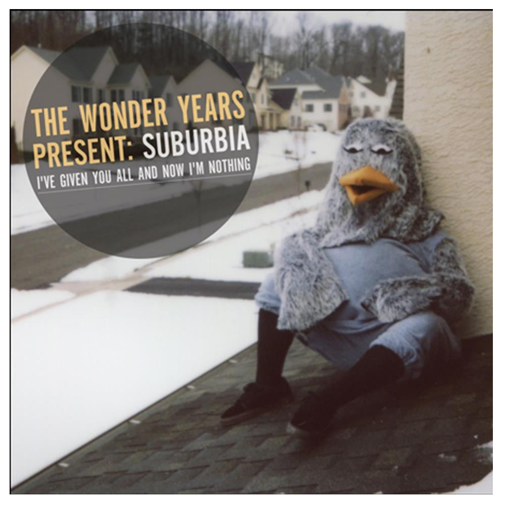 A person in a large gray bird costume slouches against a wall on a snowy suburban rooftop. The Wonder Years present: Suburbia Ive Given You All and Now Im Nothing.