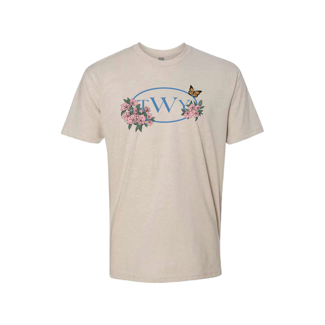 Beige The Wonder Years t-shirt featuring an exclusive blue oval with TWY, surrounded by pink flowers and a small butterfly above the design.