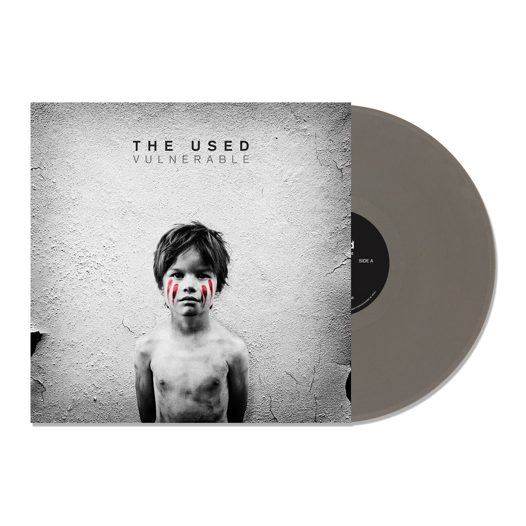 Album cover for The Used’s Vulnerable, showing a shirtless child with messy hair and red face paint against a textured white wall. Partially visible is the Limited Edition Vulnerable Silver LP. Released by The Used on April 5th, 2024.