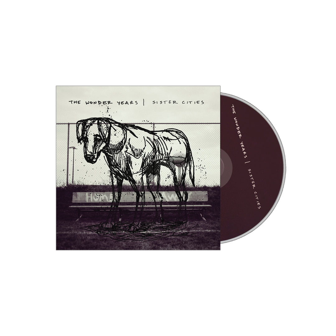 CD case and disc for Sister Cities by The Wonder Years, featuring tracks like Raining in Kyoto. Cover art shows a sketched dog on grass near a bench with handwritten album and band names above; disc is dark with white text. Brand: The Wonder Years.
