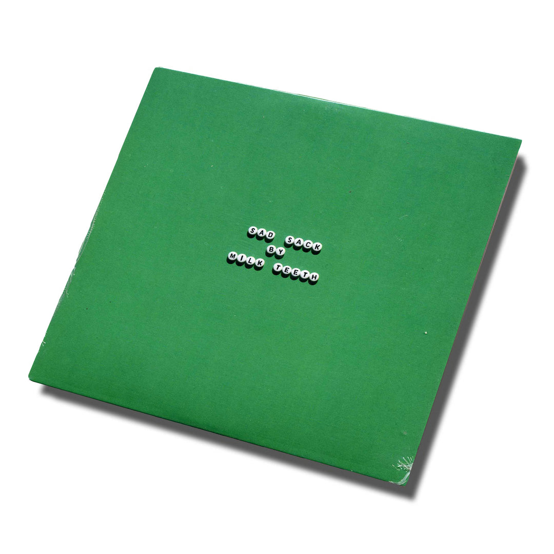 A green square album cover with white beads spelling one book by wolf tycoon in the center, set on a white background with a slight shadow—ideal for fans of the brand Milk Teeth or anyone interested in the CD tracklist.