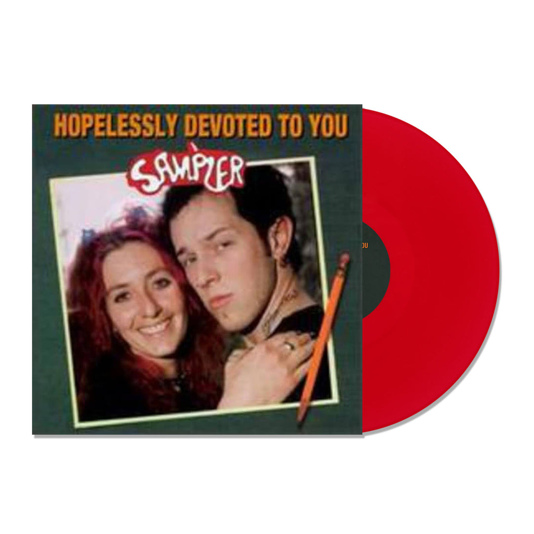 A red LP slides out of its cover, featuring two people together and smiling. The dark cover reads Hopelessly Devoted To You Sampler in yellow and white. This Limited Edition release is from Hopeless Records.