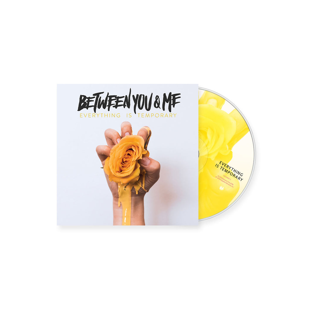 A CD and its cover for Everything Is Temporary by Between You And Me, featuring artwork of a hand squeezing a yellow rose with liquid dripping down; the disc itself also displays the vivid yellow rose image.