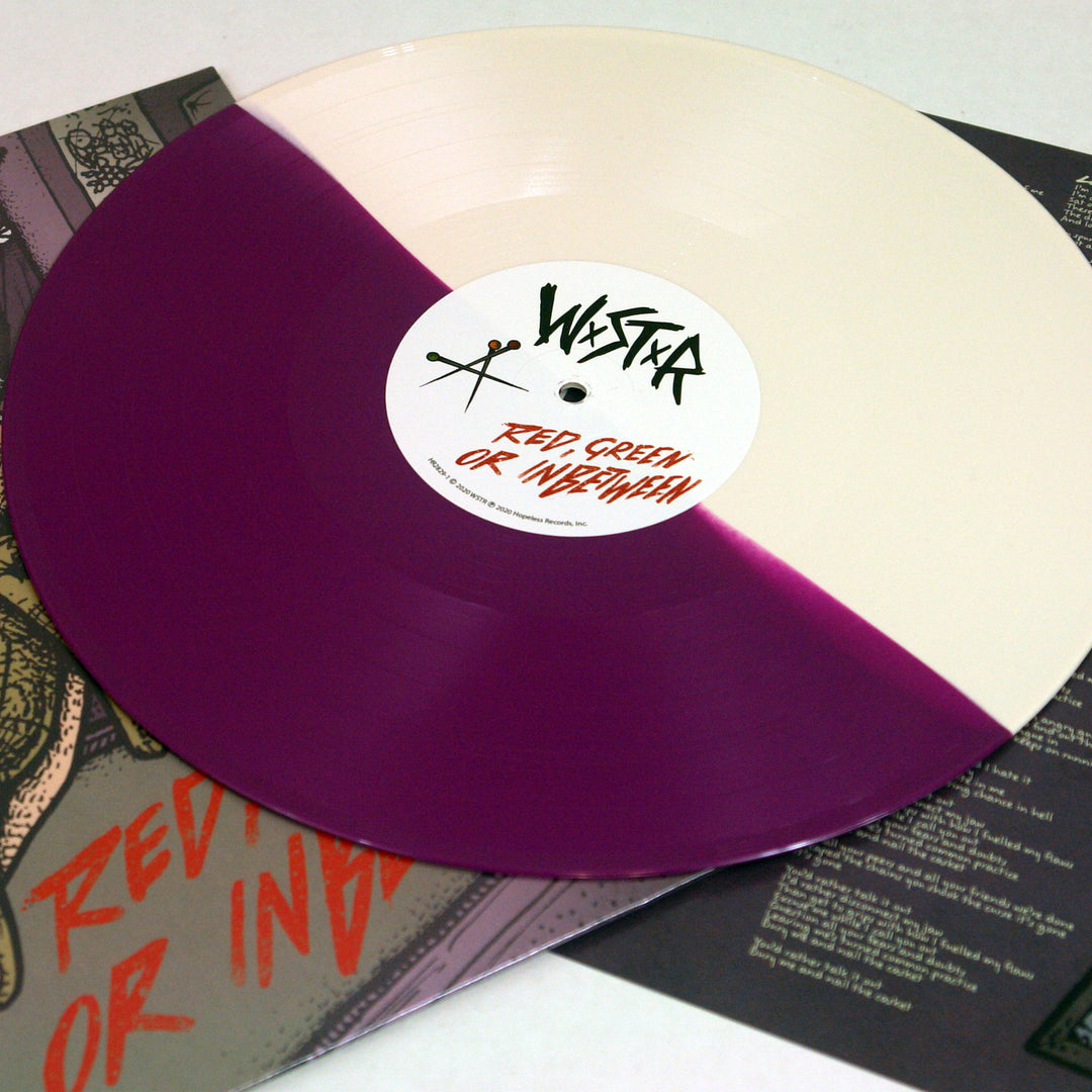 A WSTR Purple &amp; Bone Split Vinyl, featuring cream and deep purple halves, rests on its album cover. The label displays WASTE and RED, GREEN, OR INDESCRIBABLE in bold black and red—ideal for any WSTR collection.