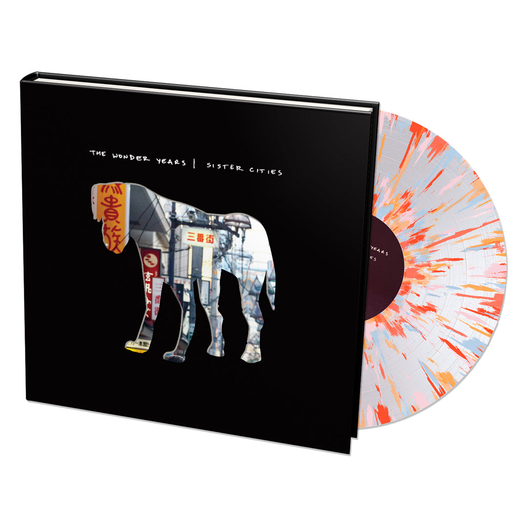 A Limited Edition vinyl with a white and orange splatter design is partly out of its black sleeve, which shows an elephant silhouette filled with an urban scene and The Wonder Years | Sister Cities text.