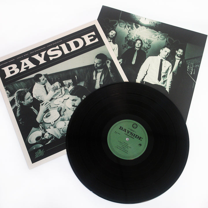 Vinyl Album cover for Bayside "Acoustic Volume 2" on a white background. Shows band eating at a diner with BAYSIDE in white text at the top. Black vinyl