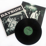 Vinyl Album cover for Bayside "Acoustic Volume 2" on a white background. Shows band eating at a diner with BAYSIDE in white text at the top. Black vinyl