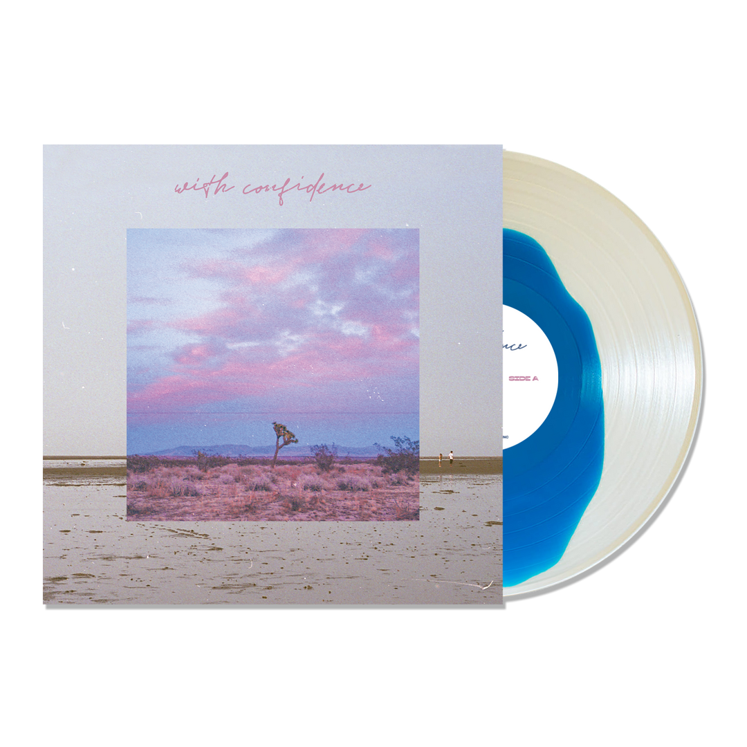 A Blue Inside Clear Variant vinyl by With Confidence is partially slid from its album cover, which displays a desert landscape beneath a pink and blue sky. With Confidence appears in pink cursive at the top.