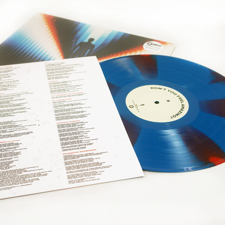 A Limited Edition blue vinyl record by Trash Boat, with its tracklist on a printed lyrics sheet and an album cover featuring a silhouette against a colorful geometric background, are displayed on a white surface.