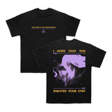 Between You And Me’s exclusive Next Level Black Tee features WELCOME TO THE ARMAGEDDON and a symbol on the front, with abstract purple artwork and bold yellow text on the back.