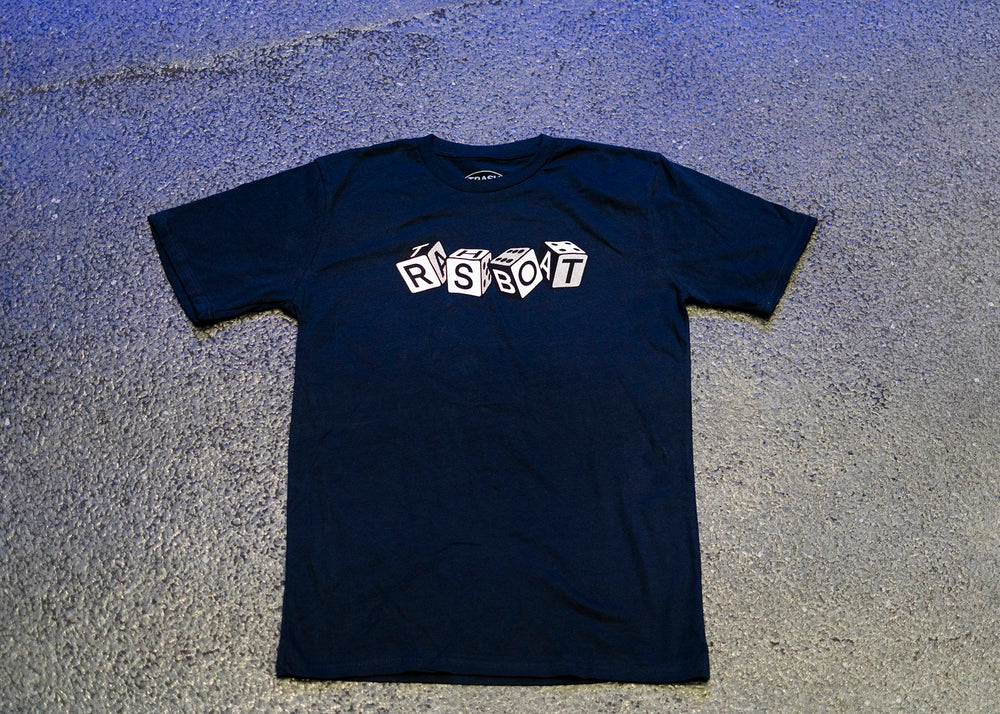 A black Trash Boat Band Merch t-shirt rests on a textured gray surface. The shirt displays RSBOT in block letters, each on a white 3D cube, reflecting the signature style of the Dice Navy T-shirt.