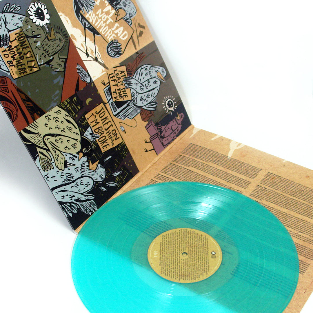 A teal vinyl record by The Wonder Years rests on an open sleeve with intricate brown and black artwork of birds, abstract designs, and JOY TEARD IMPLORE text—evoking the vibe of a Logan Circle afternoon.
