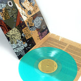 A teal vinyl record by The Wonder Years rests on an open sleeve with intricate brown and black artwork of birds, abstract designs, and JOY TEARD IMPLORE text—evoking the vibe of a Logan Circle afternoon.