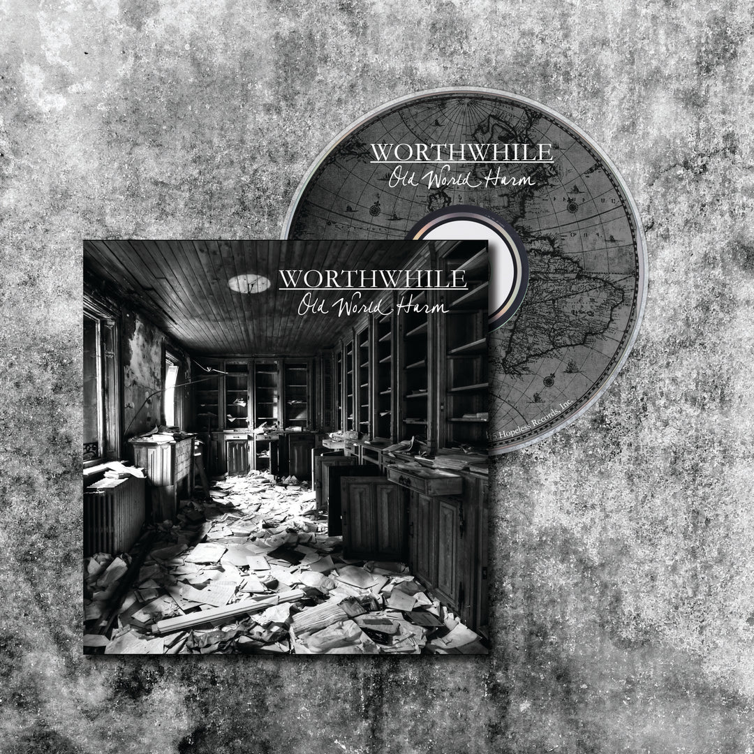A CD and case for Worthwhile: Old World Harm, featuring a black and white cover photo of an abandoned library—A Fool’s Paradise—with scattered papers and tall shelves.