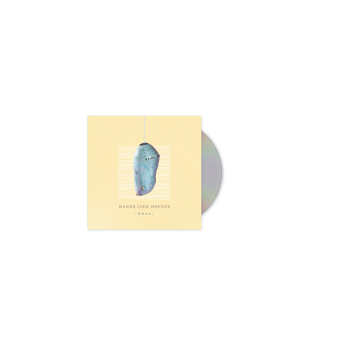A partially visible CD in a cream-colored case features a painted blue shark suspended vertically, evoking a deep-sea monster. The cover text reads Hands Like Houses -Anon-. Brand: Hands Like Houses.