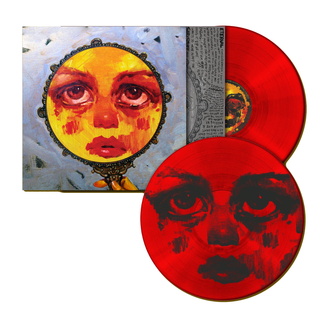 Two red vinyl records from Sweet Pill with a painted face in red and black, partially covering limited edition packaging that features a similar face in a round, ornate mirror on a light blue background.