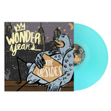 A light blue vinyl record by The Wonder Years slides from its cover, which shows illustrated city buildings at night, a pigeon with a box labeled The Upsides, and bold lettering referencing Logan Circle.