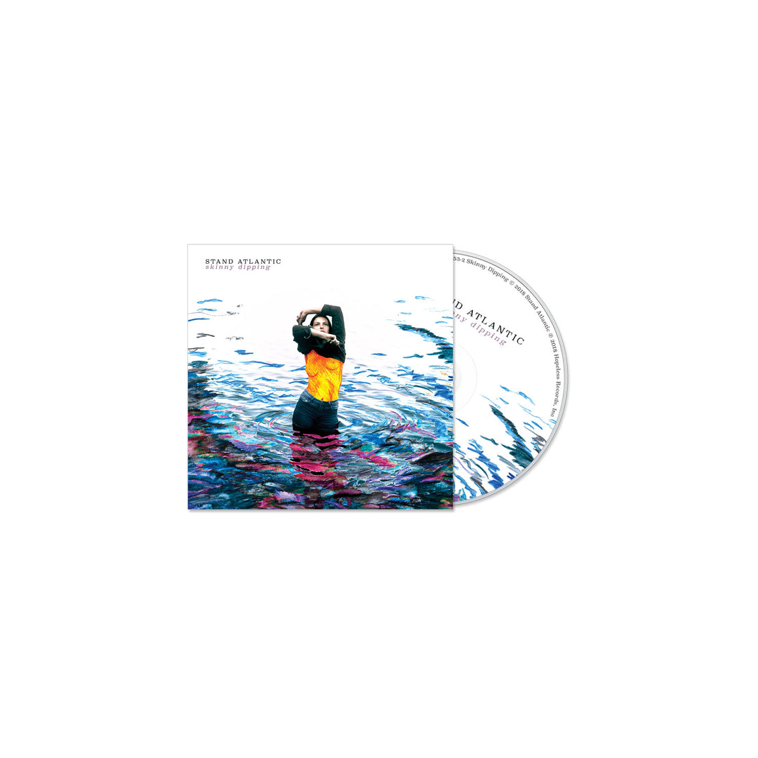 The Stand Atlantic “Skinny Dipping” album cover features a person waist-deep in vibrant, colorful water with raised arms, reflecting the energy of tracks like “Lavender Bones.” The CD displays a matching bright water pattern.