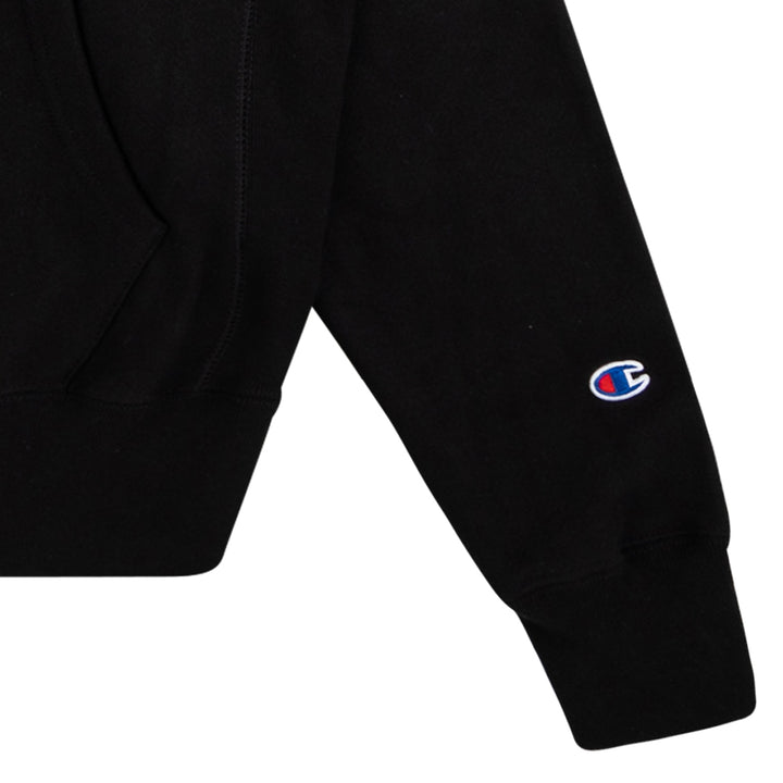 Black 100% cotton Neck Deep hoodie featuring the right sleeve with a small embroidered Champion logo near the cuff and part of a front pocket visible; classic Sonderland style.